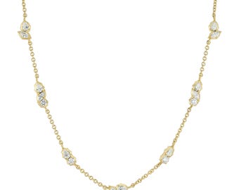 May include: A yellow gold chain necklace featuring multiple stations of small, clear, faceted diamonds. Each station consists of a cluster of pear-shaped and round-cut stones set in gold, spaced evenly along the delicate, polished gold link chain.