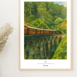 May include: A framed print depicting a brown and red train crossing a stone bridge surrounded by green foliage. The bridge has multiple arches. The text "Ella Sri Lanka" is displayed at the bottom of the print.