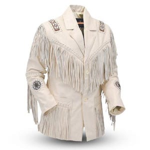 Könnte beinhalten: Cremefarbene Wildlederjacke mit Fransen an Brust, Ärmeln und Taschen. Die Jacke hat dekorative Nähte und gestickte Akzente an Schultern und Ärmeln. Sie wird mit Knöpfen geschlossen.