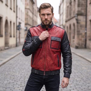 May include: A leather jacket featuring a red torso and black sleeves, collar, and hem. The jacket includes a central zip, two chest pockets with flaps, and small red circular accents on the sleeves. The design incorporates a stand-up collar.