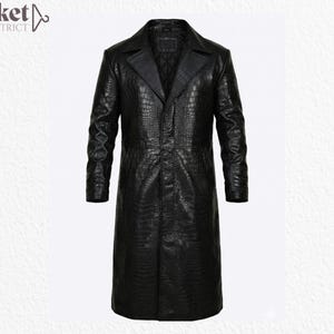May include: A black leather trench coat with a crocodile skin texture. The coat has a notched collar, long sleeves, and a button-down front. The "jacket DISTRICT" logo is in the upper left corner.
