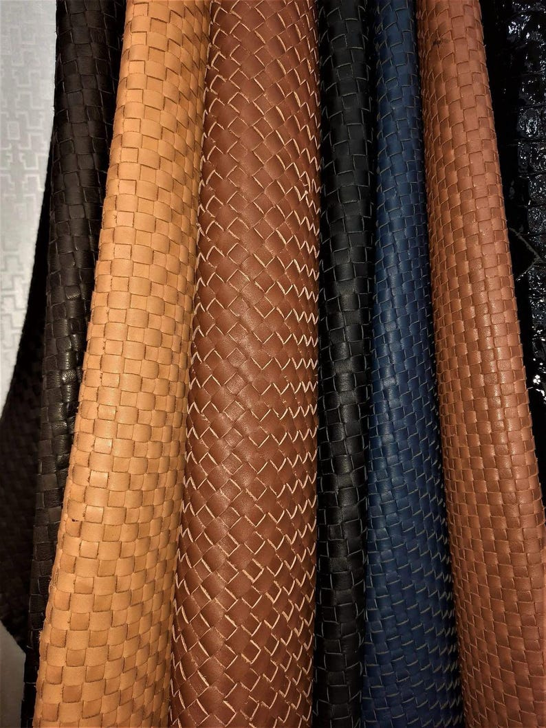 May include: A collection of vertical fabric strips featuring a woven basket-weave pattern. The strips are displayed in a variety of colours including dark brown, light tan, medium brown, black, and deep navy blue, arranged side by side.