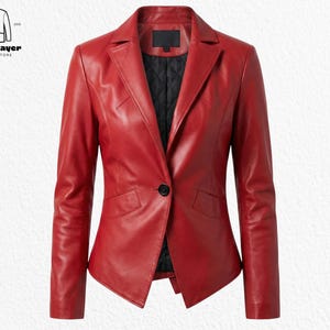 Puede incluir: Una blazer de cuero rojo con un solo botón negro. La chaqueta tiene solapas con muescas, dos bolsillos delanteros y mangas largas. El logotipo de North Layer Jackets Store es visible en la esquina superior izquierda.