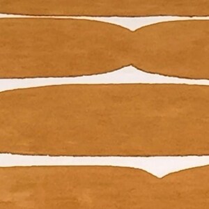 A top-down view of a mustard yellow and white wavy geometric rug, showing several repeating patterns.