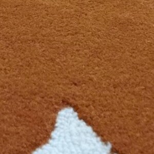 A very close-up, textured view of the mustard yellow and white wavy geometric pattern of the rug.