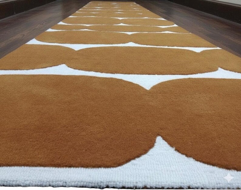 A close-up, low-angle view of a mustard yellow and white geometric runner rug with wavy shapes on a dark wood floor.