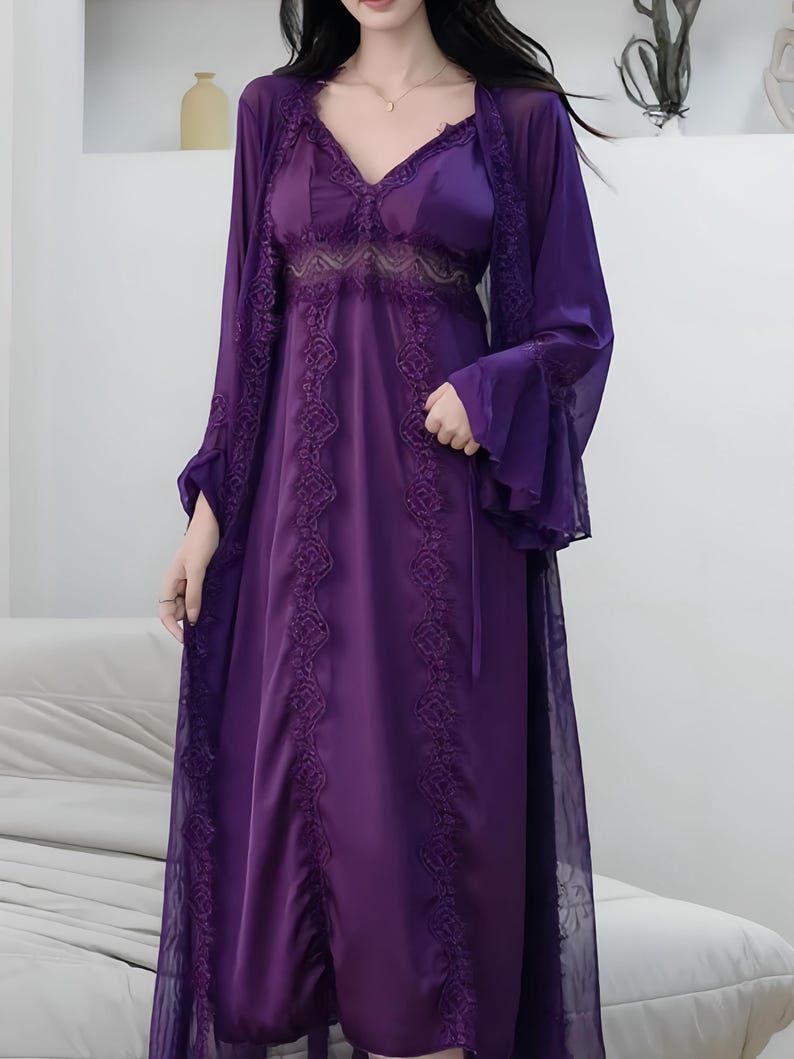 May include: A deep purple satin nightgown and matching sheer robe set. The nightgown features a V-neck with lace detailing and a flowing skirt. The robe has bell sleeves and intricate lace trim. A luxurious and elegant sleepwear ensemble.