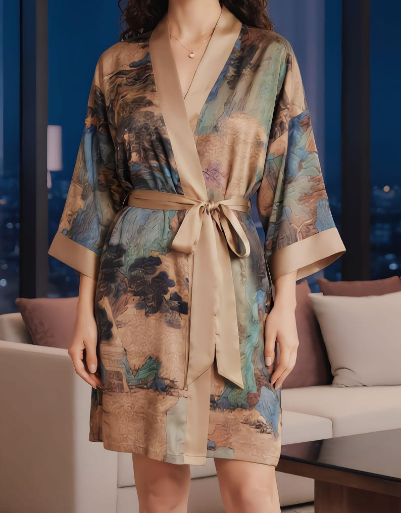 K&ouml;nnte beinhalten: Seidenrobe mit Landschaftsdruck in Braun-, Blau- und Gr&uuml;nt&ouml;nen. Die Robe hat eine beige Einfassung, einen passenden G&uuml;rtel und weite &Auml;rmel. Die Robe ist knielang und hat einen V-Ausschnitt.