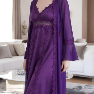 May include: A purple satin nightgown and matching sheer robe set. The nightgown features a V-neckline with lace trim and a flowing silhouette. The robe has long sleeves and lace detailing along the edges, creating an elegant and comfortable sleepwear ensemble.