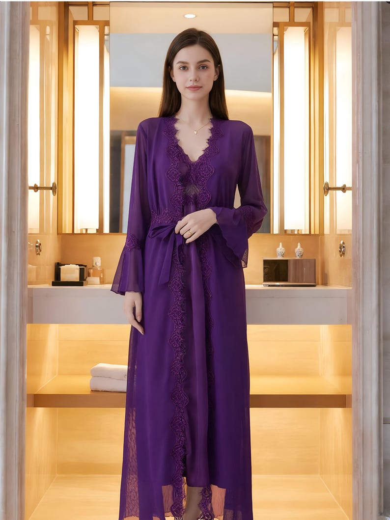 May include: A long, flowing purple robe with lace trim and bell sleeves. The robe is tied at the waist with a matching sash. The neckline is a V-shape, and the fabric appears to be sheer. The robe is worn over a matching slip.