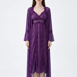May include: A purple lingerie set featuring a satin slip dress with lace detailing and a matching sheer robe. The robe has bell sleeves and lace trim. The set is designed for comfort and elegance.