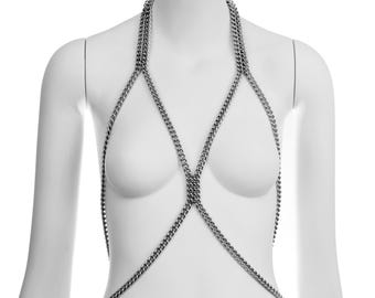 May include: A silver chain body harness with multiple criss-crossing chains.
