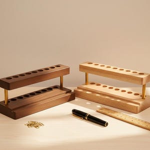 Multifunction walnut desktop organizer with 9 pen slots and phone stand, minimalist wooden office accessory with smooth polished finish, natural wood grain, and space-saving design for tidy workspaces.