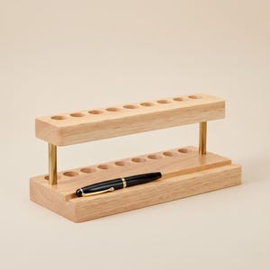 Multifunction walnut desktop organizer with 9 pen slots and phone stand, minimalist wooden office accessory with smooth polished finish, natural wood grain, and space-saving design for tidy workspaces.