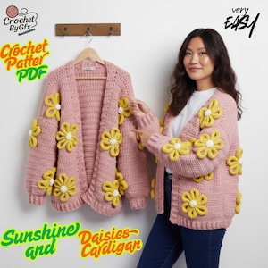 Puede incluir: Un cárdigan rosa claro adornado con grandes aplicaciones de margaritas amarillas y blancas. El cárdigan se muestra en una percha y lo lleva una persona. El texto de la imagen dice "Crochet Pattern PDF", "Sunshine and Daisies Cardigan" y "very EASY".