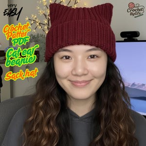 Puede incluir: Un gorro de punto color burdeos con orejas de gato. El gorro tiene dos orejas puntiagudas en la parte superior. El texto en la imagen dice "very EASY", "Crochet Pattern PDF Cat ear beanie Sack hat", y "Crochet By Gfx".