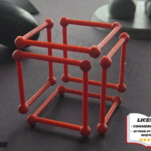 May include: A red 3D-printed cube structure with rounded joints. The geometric design is composed of straight lines and spheres, creating an open, skeletal form. The image includes a license notice.