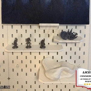 May include: A white pegboard with various items displayed on small shelves. The items include miniature figurines, a dinosaur skull, and a white abstract sculpture. A dark blue painting is at the top. A license notice is in the bottom right.