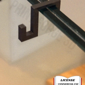 May include: A dark brown, J-shaped hook designed to attach to a dark green rod. The hook is made of a solid material and is mounted on a light-colored surface. The image also includes text that reads "LICENSE - COMMERCIAL USE - AUTHOR ATTRIBUTION REQUIRED".