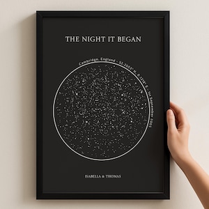 May include: Black framed print with a star map design. The text "THE NIGHT IT BEGAN" is at the top, with the location Cambridge, England, and the date 1st September 2005. The names Isabella & Thomas are at the bottom of the print.