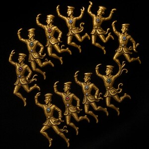 May include: A circular arrangement of twelve gold-coloured figures in mid-air poses, each with a hat and decorative details. Each figure has a coloured gem on the chest. The background is solid black.