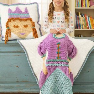 Peut inclure: Ensemble de couverture et d'oreiller sur le th&egrave;me de la princesse au crochet. La couverture est violette et sarcelle, con&ccedil;ue pour ressembler &agrave; une robe. L'oreiller repr&eacute;sente un visage de princesse avec une couronne. L'ensemble est sur fond blanc avec une bordure bleue.