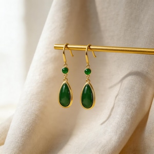 Op de afbeelding: Een set van drie keramische mokken met een gespikkelde, matte afwerking. De mokken zijn in crème, lichtgrijs en donkergrijs. Elke mok heeft een eenvoudig, minimalistisch ontwerp en een afgeronde handgreep.