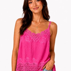 May include: A bright fuchsia sleeveless camisole top featuring delicate lace trim along the V-neckline and hem. The fabric has a subtle textured finish with intricate floral embroidery details across the chest and lower section, paired with light blue denim.