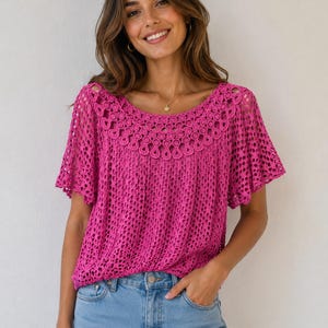 May include: A vibrant pink crochet top featuring a round neckline and short sleeves. The top showcases an intricate openwork pattern and is worn with light blue denim jeans. The top is made of a soft, comfortable material.