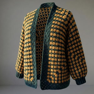 May include: A handmade, open-front crochet cardigan in a granny square pattern. The jacket features a color block design with dark teal and mustard yellow squares. The sleeves are long and the cuffs are ribbed. The cardigan is displayed on a neutral background.