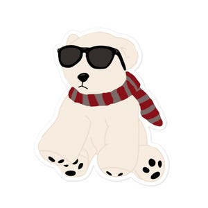 May include: A sticker of a cartoon polar bear wearing black sunglasses and a red and gray striped scarf. The bear is sitting down with its paws and feet visible, and has black paw pads.