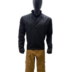 May include: A black long-sleeved shirt with a collar and a front pocket, worn with brown cargo trousers. The trousers feature multiple pockets and light-coloured stitching. The outfit is displayed on a black mannequin.
