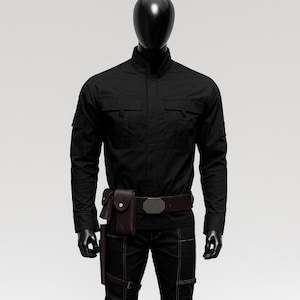 May include: Black tactical outfit on a mannequin. The outfit includes a long-sleeved shirt with two chest pockets, matching pants with reinforced stitching, a brown belt with a silver buckle, and a brown holster. The mannequin wears black gloves and shoes.
