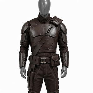 May include: A brown costume with armor plating, a high collar, and a utility belt. The outfit includes a chest plate, shoulder armor, and knee pads. The boots and gloves are also brown. The costume is displayed on a mannequin.