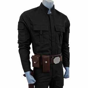May include: Black jumpsuit with multiple pockets, a brown belt with a silver buckle, and brown pouches. The costume includes a holster and a prop weapon. The outfit is displayed on a mannequin.