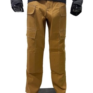 May include: Brown cargo trousers with multiple pockets and white stitching details. The trousers have a classic design with reinforced knees and a straight leg fit. The trousers are made of a durable material.