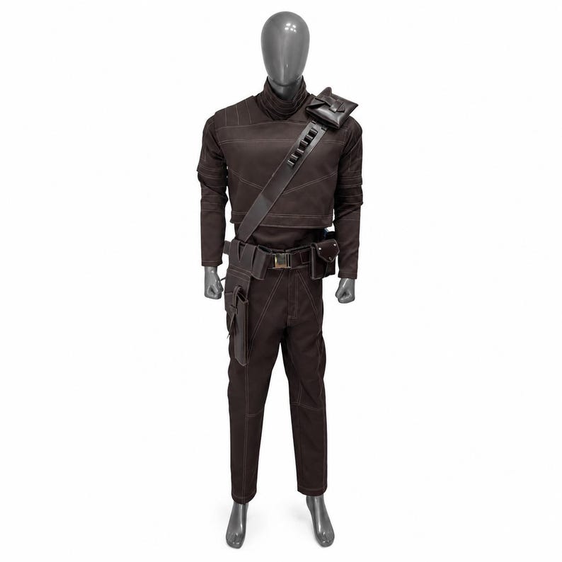 May include: Brown costume with a high collar, long sleeves, and matching pants. The outfit includes a shoulder bag, belt with pouches, and a strap across the chest. White stitching accents the seams. The costume is displayed on a mannequin.