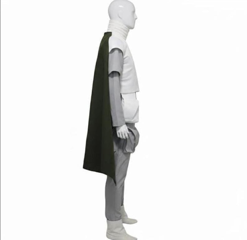 May include: A costume set displayed on a mannequin, featuring a high-neck white vest, light grey long-sleeved shirt, matching grey trousers, and a long dark olive green cape. The outfit includes a white utility pouch attached to the side.
