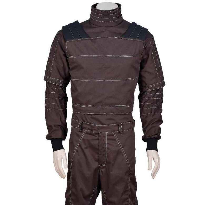 May include: A dark brown long-sleeved jumpsuit featuring a high mock neck collar, black shoulder panels, and prominent white topstitching throughout the garment. The design includes ribbed black cuffs at the wrists and a structured waistline.