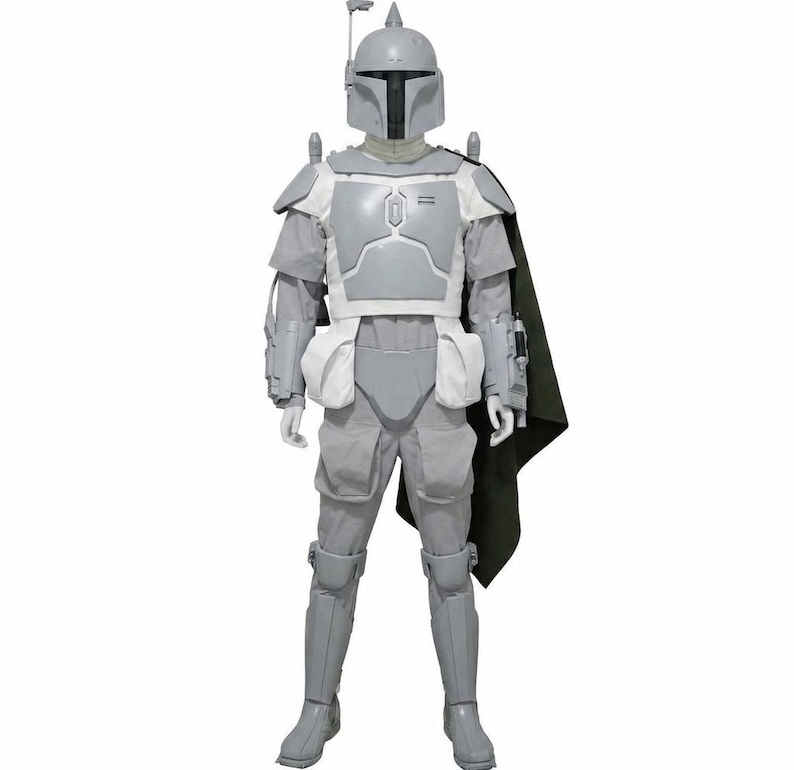 May include: A full-body suit of light grey armour featuring a helmet with a T-shaped visor and a rangefinder antenna. The ensemble includes chest plates, shoulder pauldrons, gauntlets, leg greaves, and a dark green cape attached to the left shoulder.