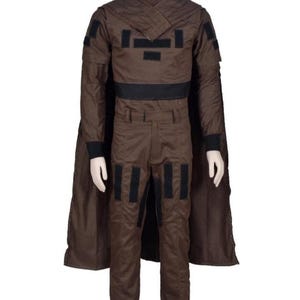 May include: A brown costume with a high collar, black accents, and a cape. The outfit includes a jacket with black patches, a black belt, and matching pants. The costume is designed for cosplay or themed events.