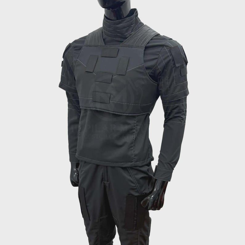 May include: A black tactical uniform set consisting of a long-sleeved shirt with a high collar, a structured chest vest with rectangular panels, and matching trousers. The ensemble features visible stitching, shoulder patches, and leg pockets.