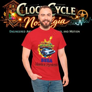 May include: A red t-shirt featuring a graphic from the movie "Back to the Future" with a DeLorean car and the text "SEGA Master System". The shirt also has the text "Clock Cycle Nostalgia" at the top.