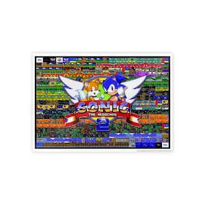 May include: A framed print featuring the Sonic the Hedgehog 2 video game logo. The artwork showcases Sonic and Tails with the game title and a colorful pixelated background. The print is encased in a white frame.