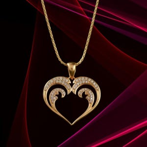 May include: A gold pendant necklace with a heart-shaped design. The pendant is embellished with small, sparkling gemstones. The necklace has a fine chain and is set against a dark, abstract background.