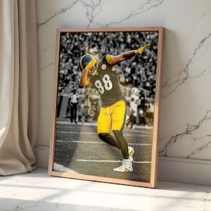 Könnte beinhalten: Gerahmter Druck eines American-Football-Spielers in einem schwarz-gelben Trikot, mitten im Dab. Der Spieler trägt die Nummer 88. Der Hintergrund ist eine Schwarz-Weiß-Stadtszene. Der Rahmen ist hellholzfarben.