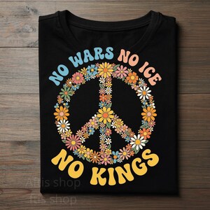 Peut inclure: T-shirt noir avec un symbole de paix composé de fleurs colorées. Le t-shirt porte l'inscription "NO WARS NO ICE NO KINGS" dans une police rétro. Le motif est centré sur le devant du t-shirt.