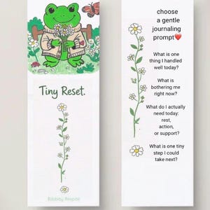 May include: Two rectangular bookmarks with white backgrounds. The left bookmark features a green frog holding flowers, a butterfly, and the text Tiny Reset and Ribbity Respite. The right bookmark lists journaling prompts with daisy illustrations.