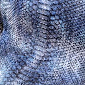 Puede incluir: Una taza de cerámica blanca con asa negra y el texto "But First, Coffee" en negrita negra. La taza se destaca sobre un fondo borroso, resaltando su diseño limpio.