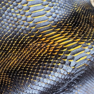 Puede incluir: Primer plano de una superficie texturizada con un patrón que se asemeja a escamas de reptil. Las escamas son principalmente negras, con acentos amarillos vibrantes. El diseño sugiere un tema natural y orgánico.